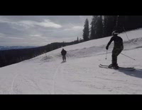 Skier jumps off orang pipe ramp and trips over orange side ropes