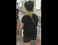 green bird sitting on shoulder of woman in black shirt