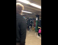 Woman with microphone sings at train station