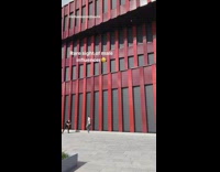 White shirt guy poses red building photographer 