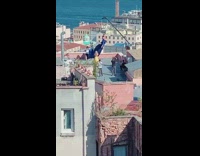 Woman sits on a swing held by a crane on the rooftop