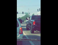 Driver of truck has feet out window 