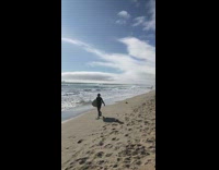 Boogie Boarder Walks Down Beach With Flipper Feet