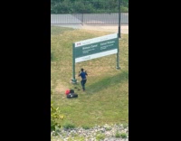 Man dances front of Canada park signage