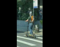 Guy wearing knights helmet rides electric scooter 