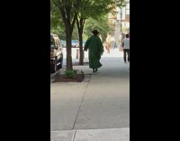 Guy brown hat green robe dress sidewalk 