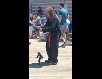 Man in black martial arts clothing plays with puppet marionette 