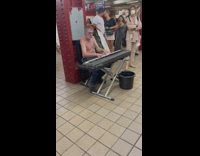 Shirtless old man play piano at subway