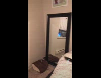 Black cat in sombrero hat rolling in bed