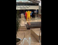 Four men Teletubbies costume dances beside bar