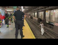 Police officers and firemen trying to get man out of train tracks
