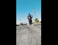 Guy does wheelie on motorcycle lets foot drag on ground 