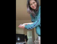 Girl blue sweater holding grey hamster in her hand throws at camera 