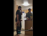 Guy kitchen holding dog one arm 