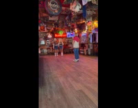 Two women cowboy outfit dances inside bar