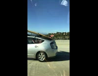 yellow surfboard on silver prius