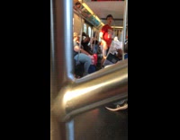 Guy wearing red powered by swag shirt responds to homophobes by singing song on subway train