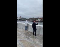 Man handstand on corner of rooftop balcony