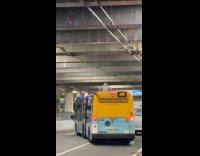 Guy on hoodie sits on bus roof