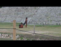Woman in dress kneels and prays in front of the pyramid