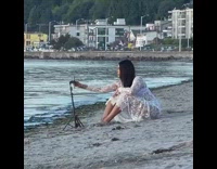 Girl white transparent dress sit beach tripod