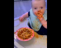 Baby eating spaghetti slurps pasta strand