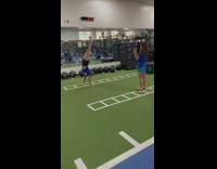 Woman in blue top handstand walk inside the gym
