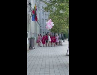 Girl hold balloons between pink dress women