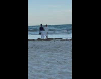 Man white robe put shades on beach