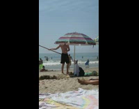 Black shorts guy spins wood stick beach 