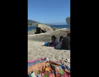 Black shirt girl leans back grey rock 