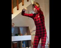 Boy wearing red onesie dances living room 
