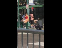 Woman in red bikini balances on sidewalk barrier