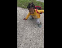 Little kid poses as spiderman on sidewalk 