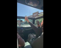 girl holds coffee up open car
