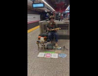 Guy performing guitar live music in subway station