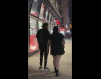 Girl in black skirt walks down sidewalk and balances water bottle on her head, CVS pharmacy
