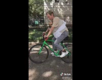 Guy rides bike with dog on chest