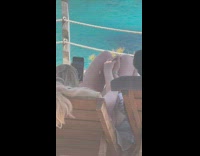 Couple on wooden beds hold hands beach