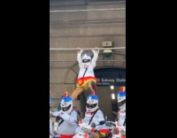 Collab WINY - Man wears buldak costume hangs on scaffolding