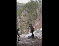 Guy dances falling water melting snow mountain 