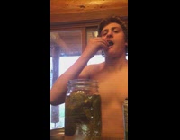 Shirtless guy records himself eating pickle out of jar and then opens soda and drinks it