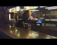 Bartender slides beer on the bar table and man catches it