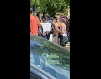 Girl hold sign board protest black car