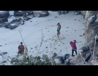 Woman in green dress poses at the beach shore