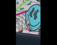 Girl raise foot beside large blue smiley