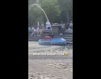 Shirtless guy tries to kill a floatie in fountain 