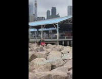 Guy backpack pushups on boulders New York