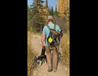 Guy blue shirt carry backpack dog sleep  