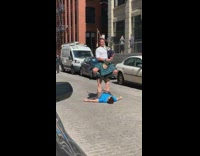 man plays bag pipes while standing on another man